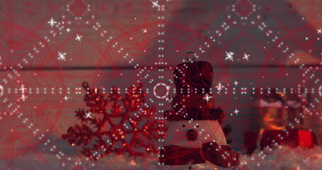 Displaying snowman figurine wearing black top hat, red scarf at home, with red snowflake ornament