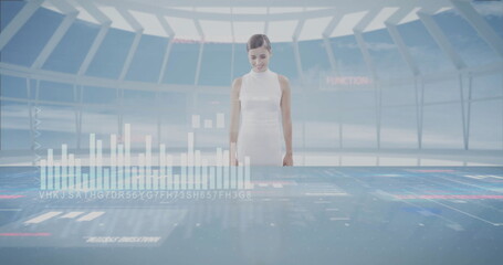 Operator in uniform examining holographic charts on table in control room, with translucent panels
