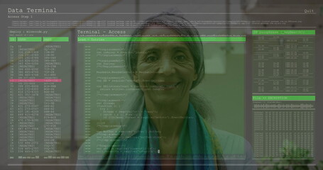 Mature Indian woman monitoring code snippets in office workspace, with translucent display panels