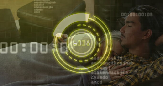 Couple reclining on dark living room sofa viewing data via smartphone with HUD overlay