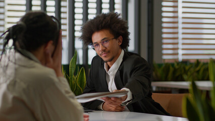 Two businessmen in business office African American leader insurance bank agent reading resume...