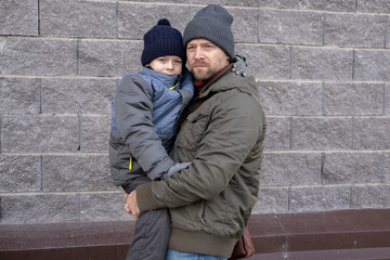 Father and son walking down on sidewalk together. Portrait of a handsome middle-aged man with...