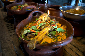 Mangut Lele, delicious catfish stew with yellow sauce, spicy catfish curry with coconut milk on a clay pan