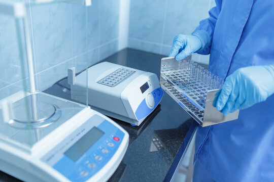 Lab Technician Handling Test Tube Rack with Digital Lab Equipment for Medical Diagnostics and Research