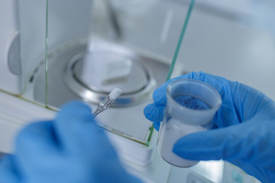 Lab Technician Weighing Chemical Powder on Precision Balance for Scientific Research and Pharmaceutical Analysis