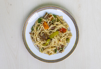 Delicious beef noodles with capsicum, tomato, green chili on a ceramic plate, ready to eat. Top...