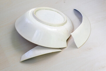 Melamine bowl broken. Fragments scattered after falling. Household accident concept.