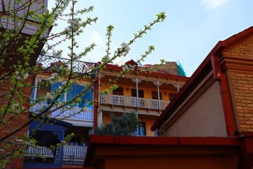 Traditional Georgian wooden house with large balconies on the edge of a rocky cliff in the old town...