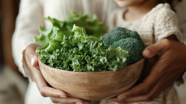 A caring adult holds a bowl filled with fresh vegetables, representing a nurturing moment while promoting healthy eating habits and the importance of family values.