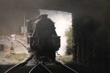 A Powerful Steam Train Engine Entering a Dark Tunnel.