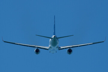 Airplane in the blue sky. An airplane moving away after takeoff