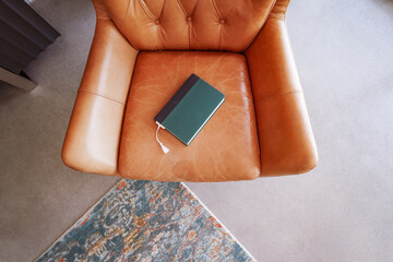 Overhead view hardbound book on leather chair