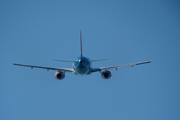 Airplane in the blue sky. An airplane moving away after takeoff