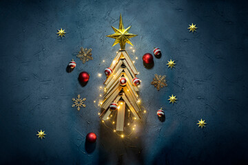 Vintage books arranged in a Christmas Tree shape on a dark blue background. New Year in the library concept. Literature for winter evenings during the holidays.