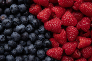 Blueberries and raspberries close-up as a background.