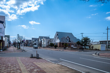 BIEI, JAPAN - APRIL 13 : Biei downtown cityscape view along city roads and buildings in peaceful environment, late winter season, no snow in town, on April 13, 2025, Biei, Hokkaido, Japan.