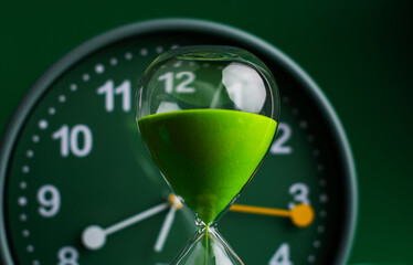 Hourglass stops time of work and life. Process and rules of limited time. Hourglass photo in studio.