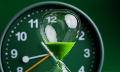 Hourglass stops time of work and life. Process and rules of limited time. Hourglass photo in studio.