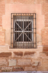 Stone facade with window with wrought iron lattice in Spain