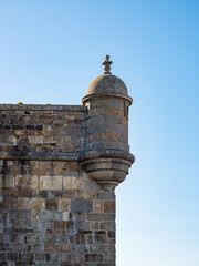 Stone turret of St Malo rampart, Brittany, France &ndash; historic coastal fortification with sentry box under clear blue sky, medieval military architecture detail.