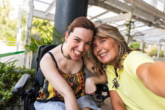 Happy disabled woman taking a selfie with her mother