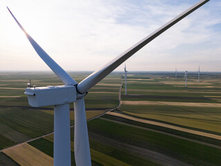 Aerial view of wind turbine on an agricultural filed at sunset. Close up of blades