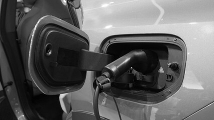 An electric vehicle charging port with a plugged in charging cable