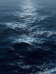 Fototapeta premium Aerial view of the dark blue ocean with textured water patterns and light reflections.