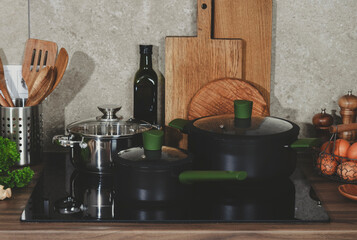 Bright kitchen with countertop, showcasing artisan cookware on induction oven for preparing...