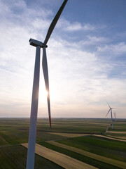 Aerial view of wind turbine on an agricultural filed at sunset. Close up of blades