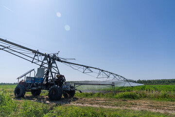 Autonomous machine is moving watering pivot along irrigation canal