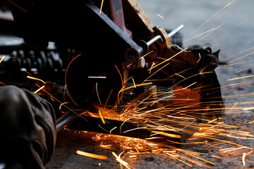 cutting a steel plate with an electric cutting wheel at a factory
