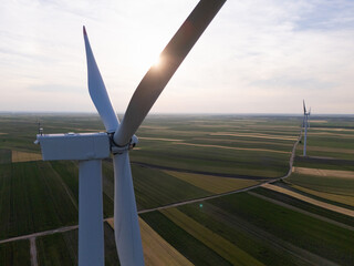 Aerial view of wind turbine on an agricultural filed at sunset. Close up of blades