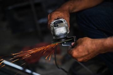 Grinding a steel plate with an electric hand wheel at a factory