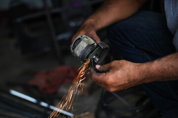 Grinding a steel plate with an electric hand wheel at a factory