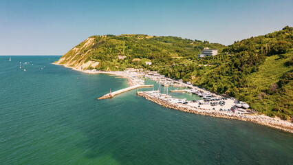 Italy, June 22, 2025: aerial view from the drone of the Vallugola Bay with its tourist port...