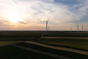 Aerial view of wind turbines on an agricultural filed at sunset