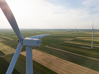 Aerial view of wind turbine on an agricultural filed at sunset. Close up of blades