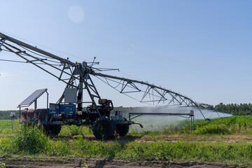Autonomous machine is moving watering pivot along irrigation canal