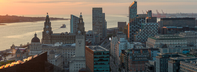 Aerial panorama of Liverpool skyline with a large boat traveling on river Mersey towards the sea