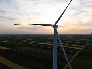 Aerial view of wind turbine on an agricultural filed at sunset. Close up of blades