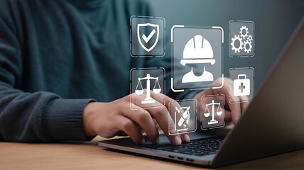 Person hands typing silver laptop screen showing digital icons safety helmet scales first aid