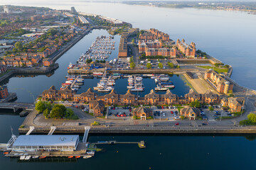 Aerial image of Liverpool docks with boats docked in the morning and river mersey on the side. 