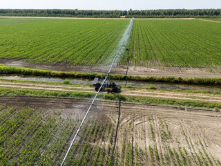 Autonomous machine is moving watering pivot along irrigation canal