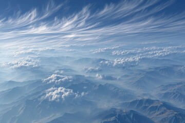 Wispy cirrus clouds casting soft shadows over majestic mountain landscape at midday