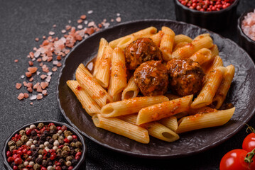 Penne pasta with meatballs in tomato sauce with salt and spices. Italian food penne pasta