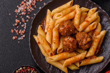 Penne pasta with meatballs in tomato sauce with salt and spices. Italian food penne pasta