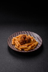 Penne pasta with meatballs in tomato sauce with salt and spices. Italian food penne pasta