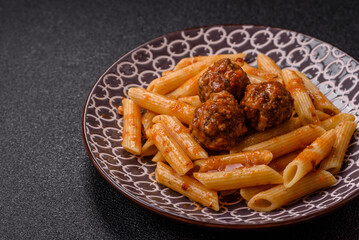 Penne pasta with meatballs in tomato sauce with salt and spices. Italian food penne pasta