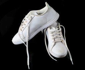 Worn Out White Sneakers with Visible Dirt on Black Background Close Up